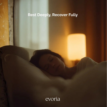 Evoria lifestyle image of a woman experiencing deep, restful sleep in a dimly lit bedroom.